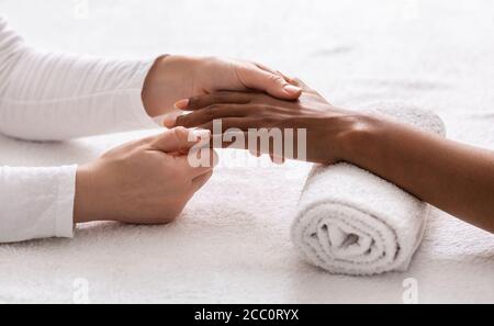 Nahaufnahme der weiblichen Therapeutin machen Handmassage für afrikanische Frau Stockfoto