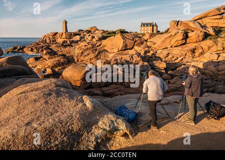 Fotografen fotografieren den Sonnenuntergang am Leuchtturm Ploumanac'h, Rosa Granite Küste, Bretagne, Frankreich Stockfoto
