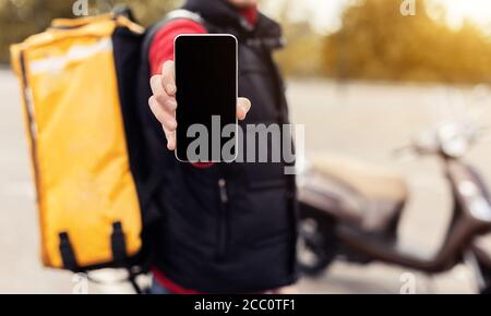 Courier Zeigt Handy Leer Bildschirm Liefert Lebensmittel Im Freien, Abgeschnitten, Mockup Stockfoto