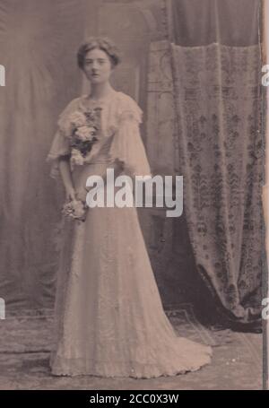 Vintage schwarz-weiß Foto von einer Braut in der Hochzeit Kleid und halten Blumen 1900er Stockfoto