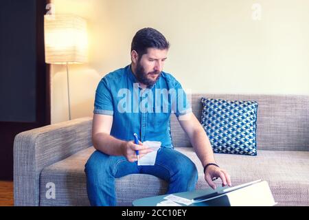Reifer Mann zu Hause Finanzen online mit digitalen Tablet Stockfoto