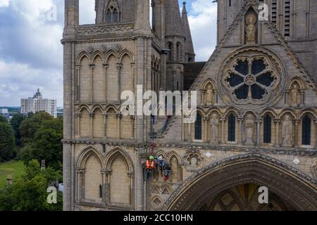 Die Steinmetz Kate Holmes von Architectural & Heritage Scanning Ltd seils down Peterborough Cathedral, um einen Laserscan auf dem durchzuführen, was das Team behauptet, das am meisten digital aufgezeichnete historische Gebäude der Welt ist, vor Westminster Abbey und Notre Dame Cathedral. Stockfoto