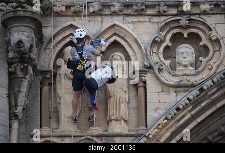 Die Steinmetz Kate Holmes von Architectural & Heritage Scanning Ltd seils down Peterborough Cathedral, um einen Laserscan auf dem durchzuführen, was das Team behauptet, das am meisten digital aufgezeichnete historische Gebäude der Welt ist, vor Westminster Abbey und Notre Dame Cathedral. Stockfoto