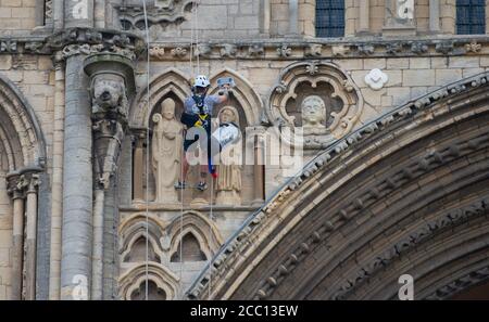 Die Steinmetz Kate Holmes von Architectural & Heritage Scanning Ltd seils down Peterborough Cathedral, um einen Laserscan auf dem durchzuführen, was das Team behauptet, das am meisten digital aufgezeichnete historische Gebäude der Welt ist, vor Westminster Abbey und Notre Dame Cathedral. Stockfoto