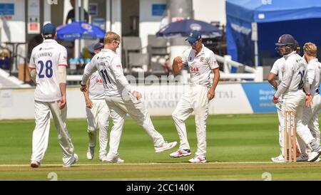 Hove UK 17. August 2020 - Alastair Cook von Essex feiert mit Bowler Simon Harmer mit etwas Fuß klopfen, nachdem er einen scharfen Fang genommen hatte, um Sussex Aaron Thomason für 30 Läufe während des 3. Tages des Bob Willis Trophy Cricket-Match zwischen Sussex und Essex zu entlassen Platz hinter verschlossenen Türen ohne Fans auf dem 1st Central County Ground in Hove : Credit Simon Dack / Alamy Live News Stockfoto