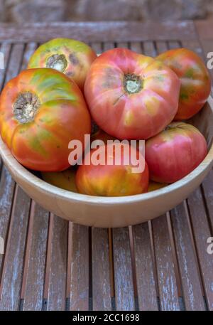 Eine Schüssel voll mit frischen Moruno Tomaten in einem hölzernen Hintergrund Stockfoto