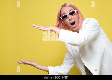 Frau gestikuliert mit Händen zeigt große und große Zeichen Stockfoto