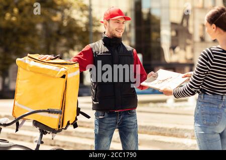 Guy Geben Paket An Kunden Mädchen Stehen In Städtischen Bereich Stockfoto