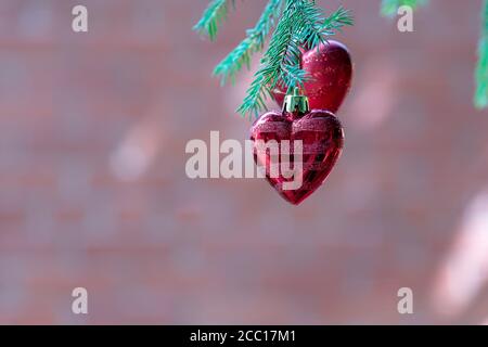 Rotes Herz auf weihnachtsbaum als Feiertagsdekoration. Frohe weihnachten und ein glückliches neues Jahr Grußkarte. Stockfoto