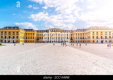WIEN, ÖSTERREICH - 23. JULI 2019: Schloss Schönbrunn, Deutsch: Schloss Schönbrun, barocke Sommerresidenz der Habsburger Monarchen in Hietzing, Wien, Österreich. Panoramablick auf die Fassade vom Haupthof. Stockfoto