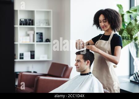 Fröhlicher Kerl immer neue Frisur bei Friseuren, leeren Raum Stockfoto