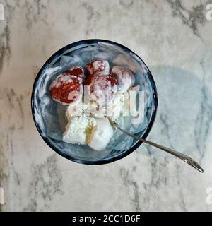 In einer Glasvase weißes Eis mit Erdbeeren. Blick von oben Stockfoto