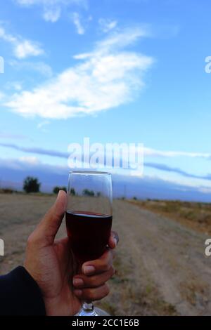 Ein Glas türkischer Tee in der Hand mit Blau Himmel als Hintergrund Stockfoto