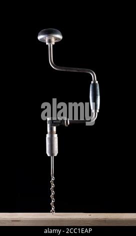 Old Fashioned Brace Hand Drill auf einem schwarzen Hintergrund mit Seitenbeleuchtung Stockfoto
