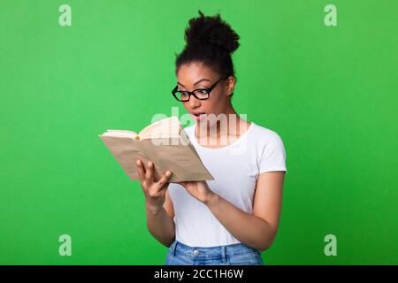 Junge schwarze Dame trägt Brille Buch lesen Stockfoto