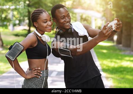 Black Millennial Paar Unter Selfie Auf Smartphone Während Sport Gemeinsam Im Freien Stockfoto