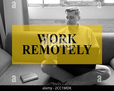 Remote-Konzept arbeiten. Ein Mann sitzt auf der Couch und arbeitet an einem Laptop. Stockfoto
