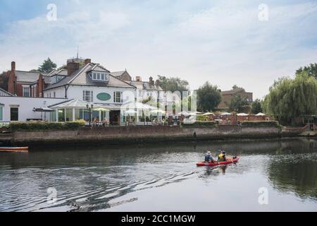 Beccles Hotel, Blick auf ein reifes Paar in einem Kanu, das am Waveney House Hotel in Beccles, Suffolk, East Anglia, England, Großbritannien, vorbeirudert Stockfoto