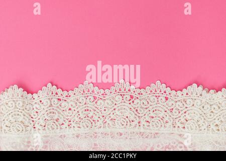 Weiße zarte Spitze auf rosa Hintergrund. Textur. Für Text platzieren Stockfoto