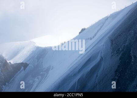 Eine Gruppe von Bergsteigern auf einem Bergrücken, der zur Aiguille du Midi, oberhalb von Chamonix, in Frankreich führt Stockfoto