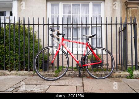 Red Boardman Fahrrad lehnt gegen Metallzaun Stockfoto