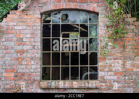 Kaputte Fenster in einem verlassenen Industriegebäude. Teil eines verlassenen Gebäudes mit kaputten Fenstern. Stockfoto