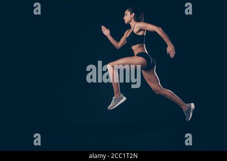 Full size Profil Foto kurze Sportanzug Dame Sprint laufen Jogger inspiriert Rennen erster Platz Mitglied isoliert schwarz zu gewinnen Hintergrund Stockfoto