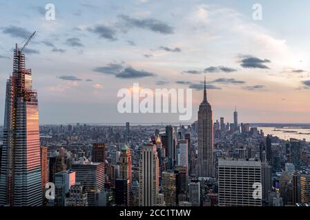 Brennender roter Sonnenuntergang spiegelt sich in den Wolkenkratzern von Manhattan wider Stockfoto