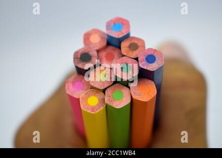 Person, die einige verschiedene farbige Holzbleistift Buntstifte in seinem hält Eigene Hand Stockfoto