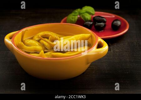 Chilischoten mit Oliven auf Holztisch, Nahaufnahme Stockfoto