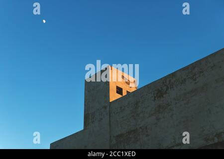 Beton verlassene Industriegebäude während Sonnenuntergang mit orangenen Licht und blauen Himmel und Mond, Merida, Yucatan, Mexiko Stockfoto