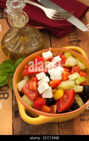 Schüssel griechischen Salat mit Feta-Käse und schwarzen Oliven auf Holztisch, Nahaufnahme Stockfoto