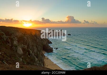 sonnenaufgang bricht über logan Rock und Pedn Vounder Strand in der Nähe porthcurno im äußersten Westen von cornwall Stockfoto