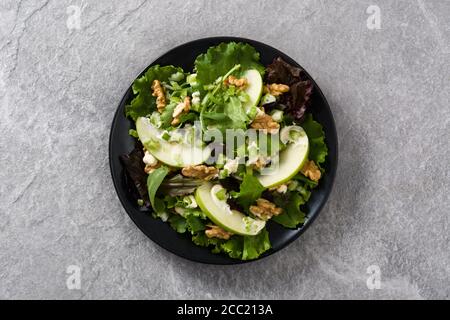 Frischer Waldorfsalat mit Salat, grünen Äpfeln, Walnüssen und Sellerie auf grauem Steingrund Stockfoto