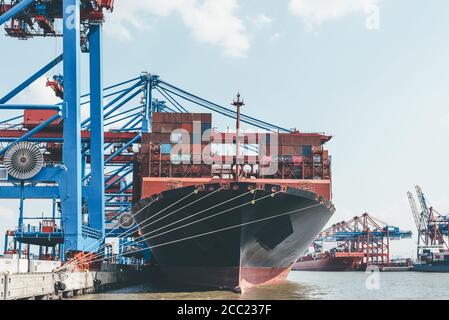 Großes Containerschiff unter Container Portalkrane im Hafen-, Transport- und Handelskonzept Stockfoto