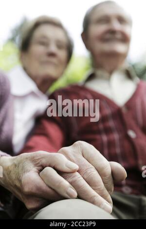 Deutschland, Köln, älteres Paar halten Hände im park Stockfoto