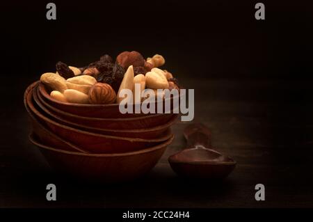 Schale von Nüssen und Rosinen auf Holztisch, Nahaufnahme Stockfoto