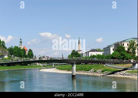 Österreich, Salzburg, Blick auf Kirche und Markartsteg über Salzach Fluss Stockfoto