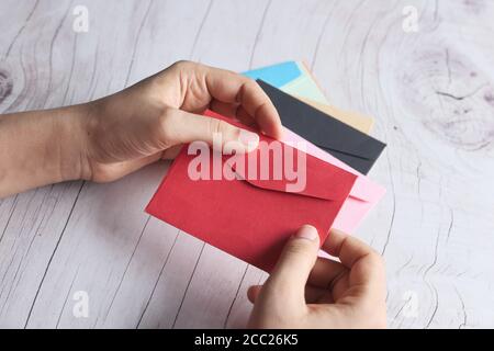 Liebesbrief in Frauen Hand auf rotem Hintergrund , Draufsicht . Stockfoto