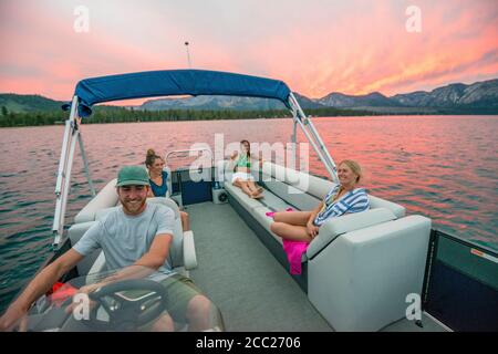 Eine Gruppe von Freunden entspannen sich auf einem Pontonboot bei Sonnenuntergang in South Lake Tahoe, Kalifornien. Stockfoto