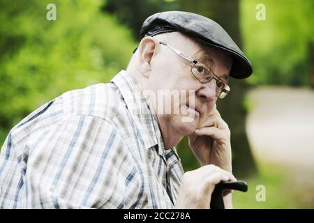 Deutschland, Nordrhein-Westfalen, Köln, Senior Mann mit Mütze und Brille im Park, Nahaufnahme Stockfoto