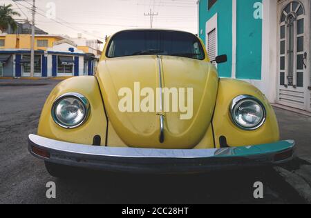 Merida, Yucatan, Mexiko - 20. November 2018: Alter gelber Volkswagen Käfer in den kolonialen Straßen bei Sonnenuntergang Stockfoto