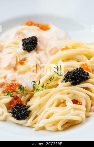 Pasta mit rotem und schwarzem Kaviar in Sahnesauce Stockfoto