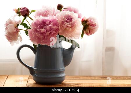 Pfingstrosen in Vase auf Holztisch, Nahaufnahme Stockfoto