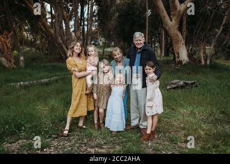 Porträt einer Familie mit mehreren Generationen lächelnd und umarmt im Feld Stockfoto