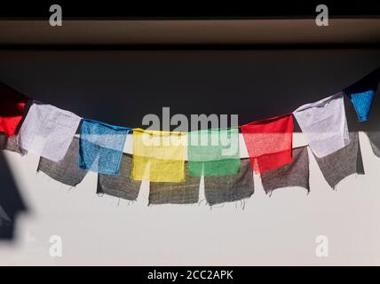 Sonne wirft Schatten der traditionellen buddhistischen Gebetsfahnen auf ein Windschutz Stockfoto