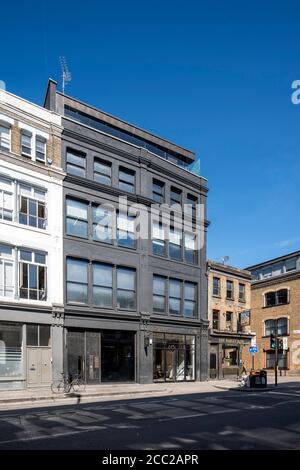 Schräge vertikale Ansicht von Curtain Road nach Nordwesten zur Rivington Street, mit Sonne auf der Höhe. Curtain Road, London, Großbritannien. Archi Stockfoto