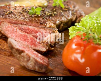 Gegrillte Rib-Eye Steak mit Kräutersauce auf Holz Stockfoto