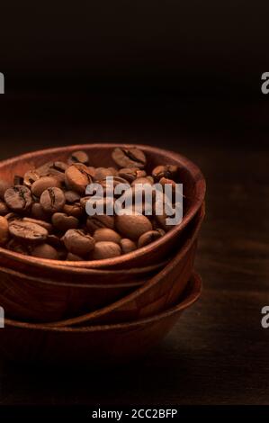 Kaffeebohnen in Stapel Schalen vor schwarzem Hintergrund, Nahaufnahme Stockfoto