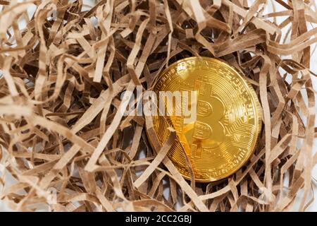 Goldene Bitcoin im Hintergrund des robusten Papiers. Geschäftskonzept. Bitcoin-Absturz. Stockfoto